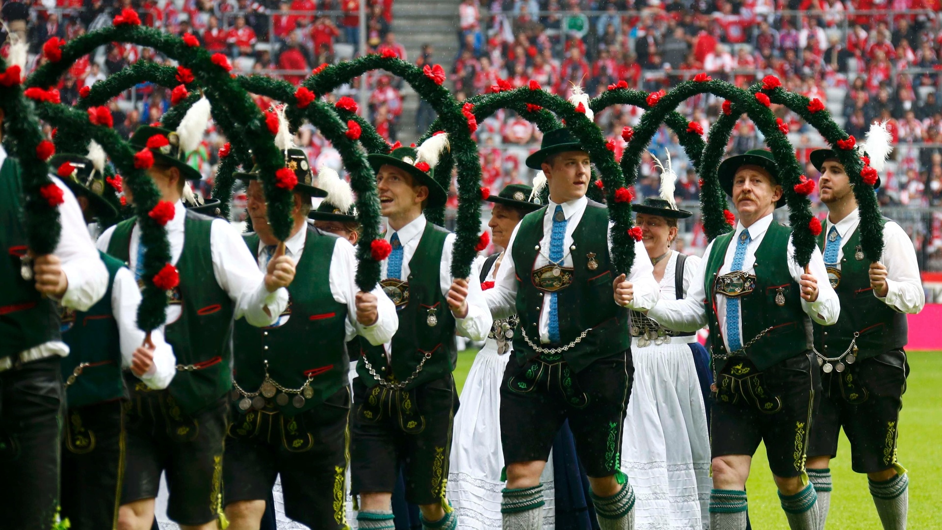 Com roupas típicas, alemães fazem uma saudação ao campeão alemão Bayern de Munique antes do jogo contra o Augsburg - KAI PFAFFENBACH / REUTERS
