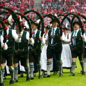 Com roupas típicas, alemães fazem uma saudação ao campeão alemão Bayern de Munique antes do jogo contra o Augsburg - KAI PFAFFENBACH / REUTERS