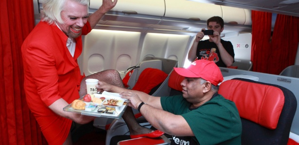 O bilionário britânico Richard Branson, dono da companhia aérea Virgin, se vestiu de aeromoça após haver perdido uma aposta para Tony Fernandes, o executivo de outra empresa aérea, a Air Asia. O executivo raspou os pelos da perna e serviu com bom humor o amigo Fernandes - Divulgação/AirAsia/Reuters