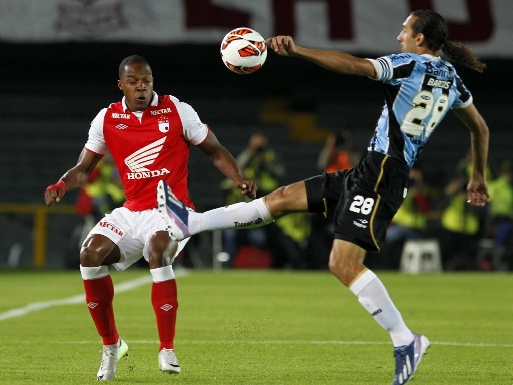 16.mai.2013 - Barcos dá chapéu em jogador do Independiente Santa Fé no jogo do Grêmio pela Libertadores - REUTERS/John Vizcaino