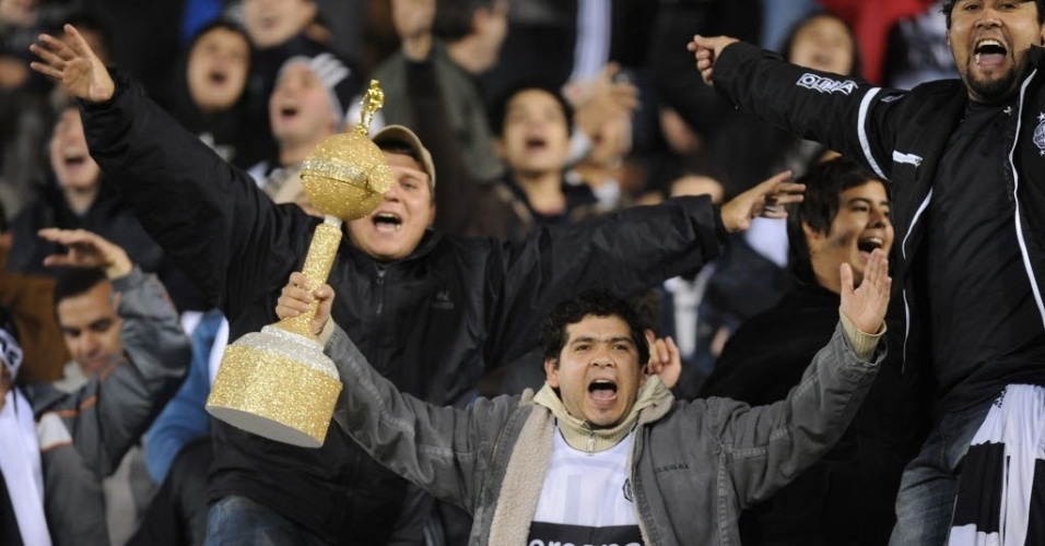 16.mai.2013 - Com réplica da taça da Libertadores nas mãos, torcedor do Olímpia comemora gol do time paraguaio contra o Tigre em partida válida pela Libertadores - AFP PHOTO/NORBERTO