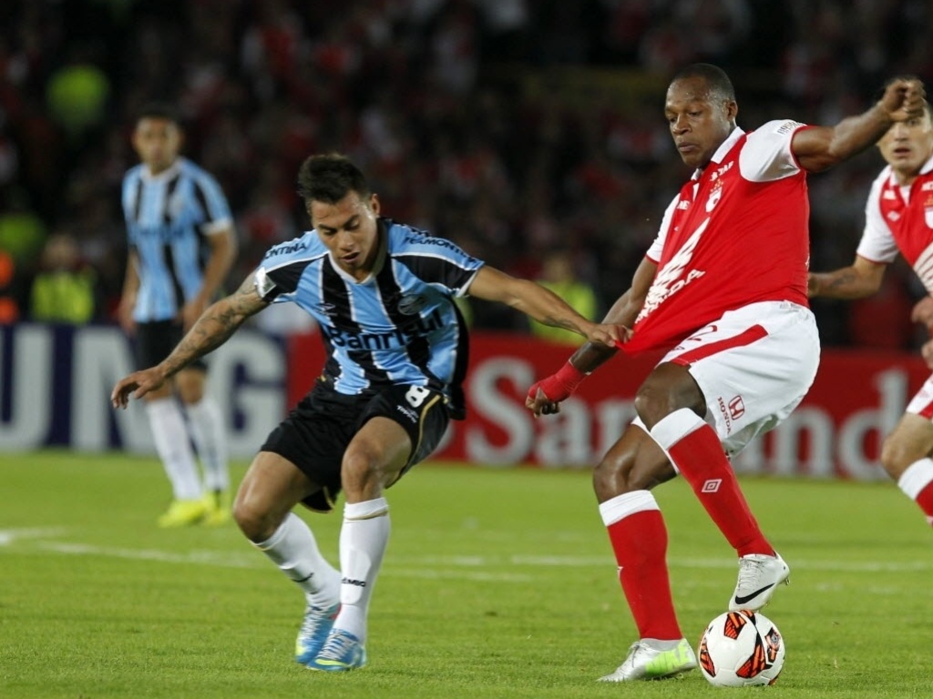 16.mai.2013 - Vargas puxa camisa do adversário na partida entre Grêmio e Independiente Santa Fé - REUTERS/John Vizcaino