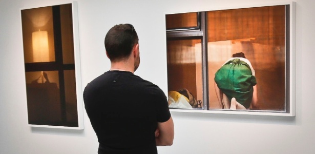16.mai.2013 - Visitante da galeria Julie Saul, em Nova York, observa fotografia de Arne Svenson, que documentou secretamente a vida de moradores de um prédio de luxo a partir de sua janela - Bebeto Matthews/AP Photo