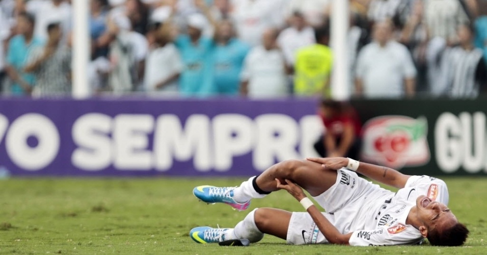 19.mai.2013 - Neymar faz cara de dor e leva as mãos à perna direita após sofrer falta no confronto contra o Corinthians