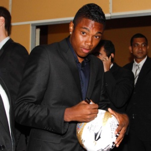 20.mai.2013 - Campeão Carioca pelo Botafogo, o atacante Vitinho chega à festa de premiação do torneio. O jogador distribui autógrafos em bolas para crianças - Marcelo de Jesus/UOL