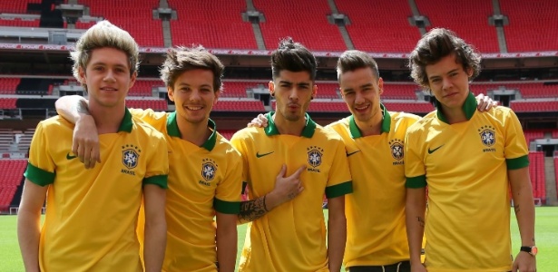 Depois de divulgarem shows no Brasil em 2014, o One Direction tiraram foto com a camiseta da seleção brasileira em um campo de futebol - Divulgação
