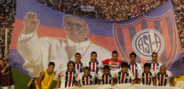 Jogadores do San Lorenzo posam com bandeirão do papa antes de jogo pelo Argentino - AP Photo/Victor R. Caivano