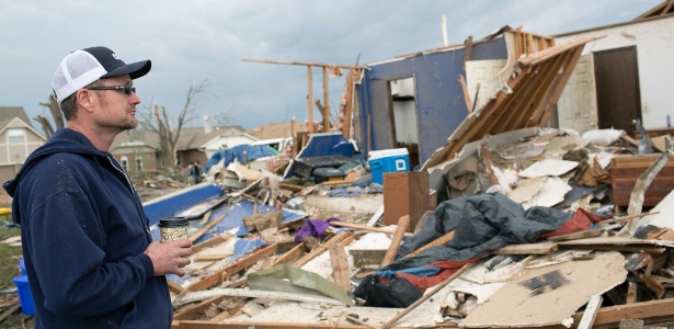 Mark Ellerd observa sua casa destruída na região de Oklahoma City (EUA) após a passagem de um tornado na última segunda-feira (20). Autoridades pediram que ele ficasse longe da casa devido aos riscos ainda presentes, mas ele decidiu acampar ao lado do imóvel por temer que a casa seja saqueada - Katherine Taylor/The New York Times