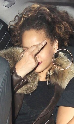 12.out.2011 - Rihanna recebe uma multa de trânsito por estacionar em local proibido em Londres, na Inglaterra, se irrita com a situação e mostra o dedo do meio para os fotógrafos que a aguardavam na frente da boate de striptease