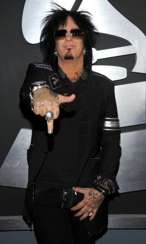 13.fev.2011 - O músico Nikki Sixx, do Mötley Crüe, sorri e mostra o dedo médio com esmalte prateado no tapete vermelho do Grammy 2011, em Los Angeles