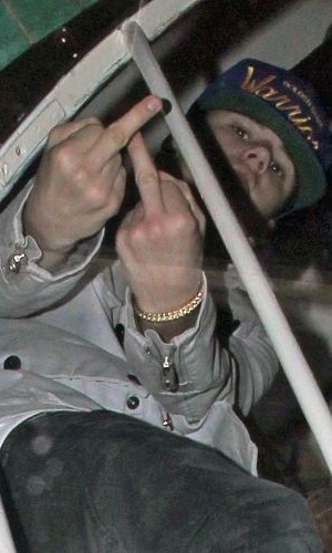 14.nov.2011 - Justin Bieber mostra o dedo do meio aos fotógrafos ao sair de um restaurante em Londres
