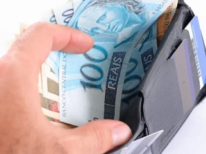 Um cofrinho com notas de Dólares dos Estados Unidos sobre um sofá azul.  Economia e investimentos. Stock Photo