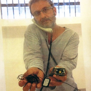 Alberto Youssef mostra equipamento que ele diz ter achado dentro da cela, na carceragem da PF em Curitiba (PR) - Reprodução