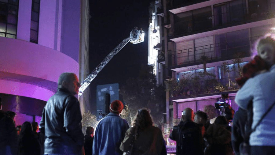Bombeiros chilenos fazem averiguação em prédio onde uma família brasileira foi encontrada morta; principal suspeita é a de intoxicação - Karin Pozo/Aton Chile/AFP