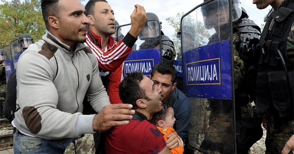 21.ago.2015 - Imigrantes imploram à polícia da Macedônia durante confrontos na fronteira com a Grécia. Oficiais lançaram bombas de gás lacrimogêneo para dispersar milhares de imigrantes e refugiados que tentavam entrar no país dos Bálcãs, provenientes da Grécia, informou um repórter da Reuters que estava na fronteira