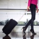 Mulher com bagagem de mão no aeroporto - iStock