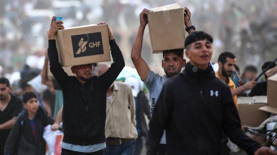 8.jun.2025 - Palestinos carregam doações da GHF (Fundação Humanitária de Gaza), grupo de ajuda privado apoiado pelos EUA 8.jun.2025 - Palestinos carregam doações da GHF (Fundação Humanitária de Gaza), grupo de ajuda privado apoiado pelos EUA