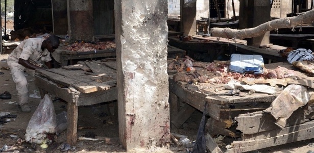 Soldado nigeriano inspeciona o local de um ataque cometido por menina-bomba em um mercado de Maiduguri