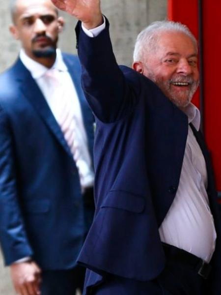 Lula acena a apoiadores observado por seguranças
