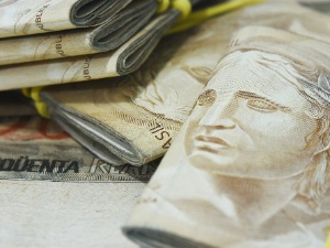 Um cofrinho com notas de Dólares dos Estados Unidos sobre um sofá azul.  Economia e investimentos. Stock Photo