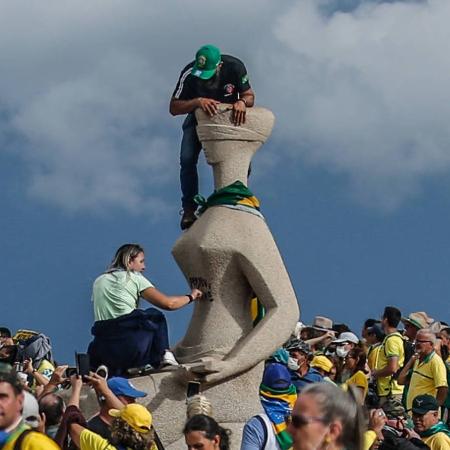 Mulher com mão na pichação 'Perdeu, mané' na estátua 'A Justiça', no 8/1