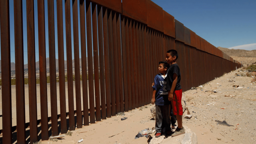 Duas crianças observam parte de uma estrutura metálica que separa os Estados Unidos do México - Jose Luis Gonzalez - 3.mai.18/Reuters 
