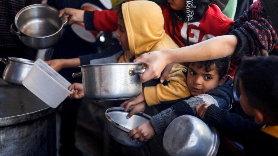 Crianças palestinas se aglomeram para receber comida na cidade de Rafah, na Faixa de Gaza