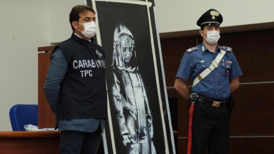 Policiais ao lado de mural atribuído ao artista Banksy recuperado na Itália - Reprodução