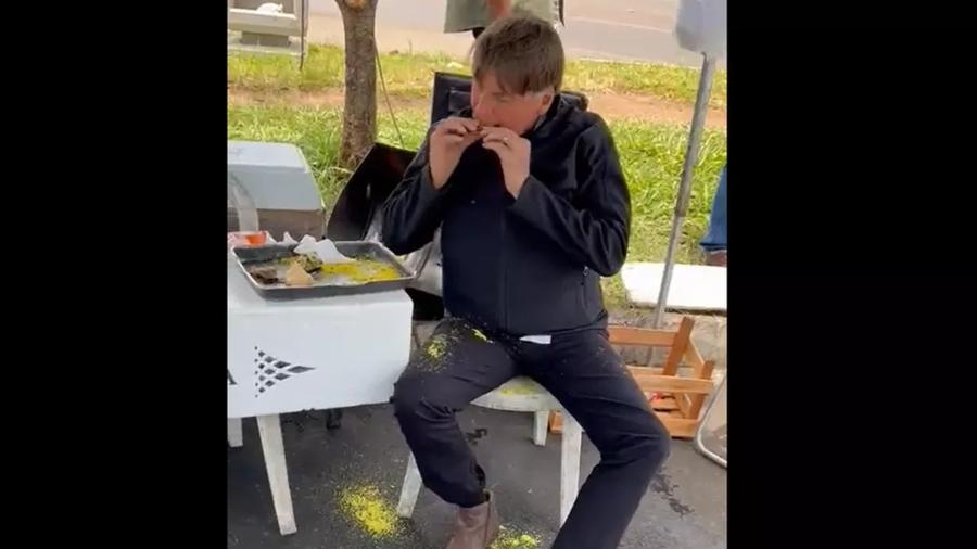 Vídeo publicado por aliados de Jair Bolsonaro (PL) mostra presidente sujo comendo frango com farofa com as mãos - Reprodução