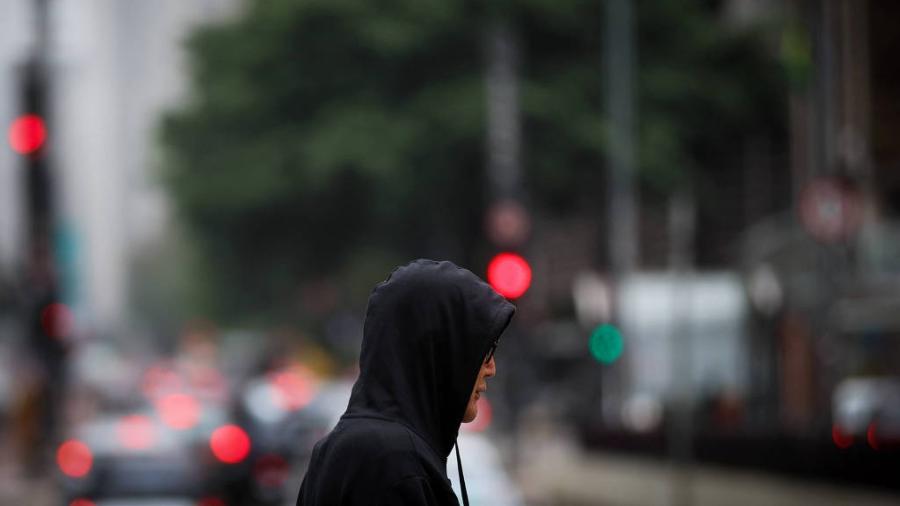 Pedestre se protege do frio na avenida Paulista, em São Paulo