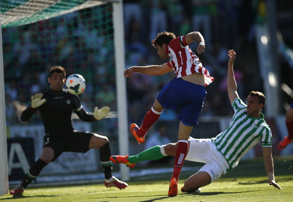 Atletico Madrid's Diego Costa (C) kicks the ball in front of Real Betis goalkeeper Antonio Adan (L), as he is challenged by Betis defender Antonio Amaya, during their Spanish First Division soccer match at Benito Villamarin stadium in Seville March 23, 2014. REUTERS/Marcelo del Pozo (SPAIN - Tags: SPORT SOCCER) ORG XMIT: MDP02