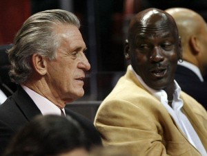 Miami Heat president and former coach Pat Riley sits in the stands with basketball great Michael Jordan during NBA action in Miami