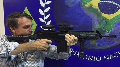 O presidente Jair Bolsonaro segura uma arma de fogo