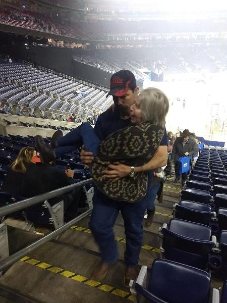 Bombeiro carrega idosa no colo após show no NRG Stadium no Texas - Reprodução/Facebook