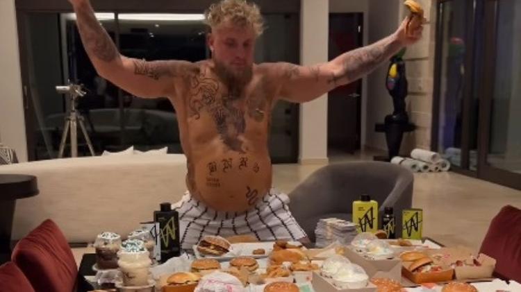 Em sua 'fase de ganho de peso', Jake Paul posou em frente a uma mesa repleta de fast food, arrancando risadas e comentários dos seguidores sobre sua "barriga de Jake grávido".