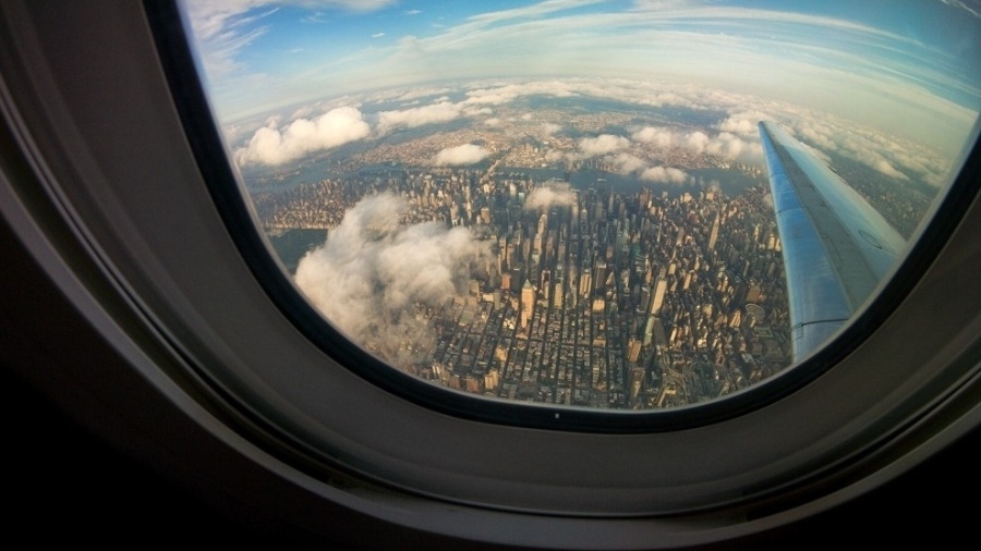 Nova York da janela de um avião; comissários podem te pedir para abrir a cortina, e isso tem a ver com segurança
