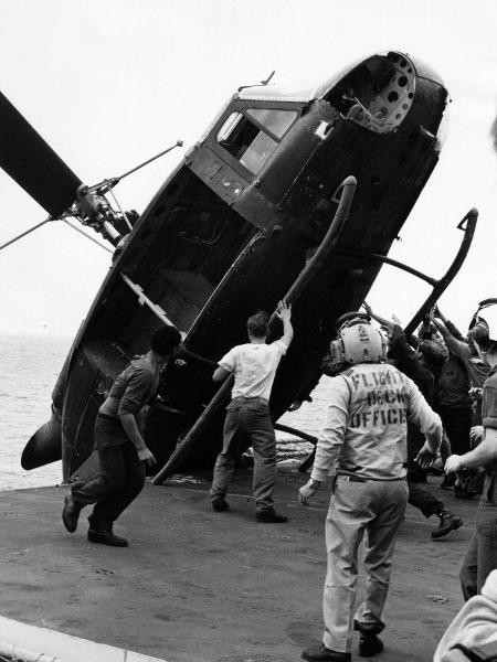 Helicóptero UH-1 Huey sendo jogado ao mar ao final da Guerra do Vietnã, durante a operação Vento Constante