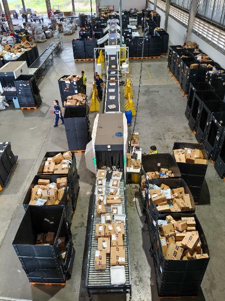  Os pacotes chegam misturados, são colocados na esteira, passam por medição e identificação e sobem na esteira rumo às bandejas de cada destino segundo os voos da empresa