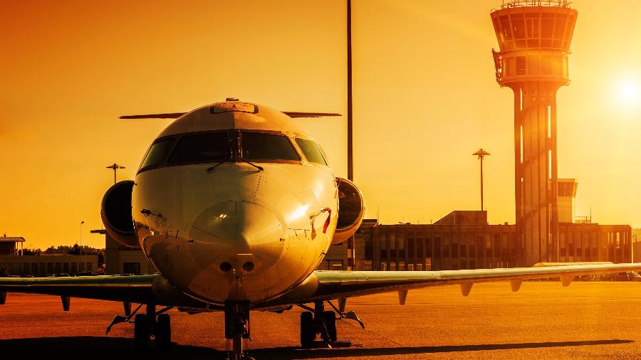 Avião durante o por do sol em aeroporto: Nova taxa ambiental pode deixar voos mais caros e mira ricos Avião durante o por do sol em aeroporto: Nova taxa ambiental pode deixar voos mais caros e mira ricos