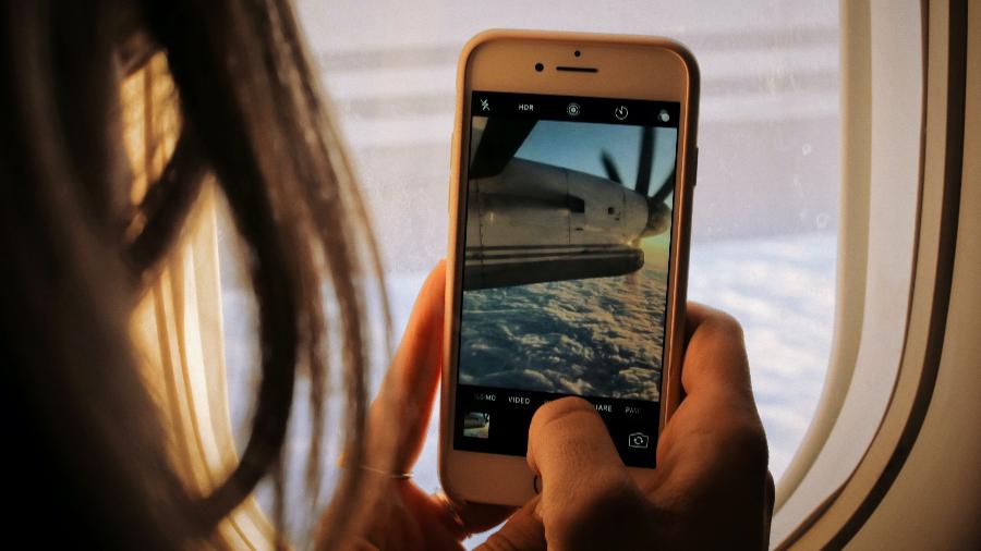 Pessoa usa Instagram para celular em avião durante voo: Tecnologia 5G deve ser liberada em 2023 para voos na União Europeia - Patrick Tomasso/Unsplash