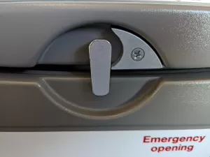 Por que mesas de fileiras de emergência do avião só destravam para um lado?