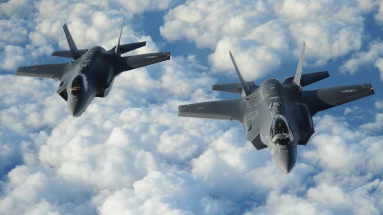 Caças F-35 israelense voam em formação exibindo a bandeira de Israel e dos EUA