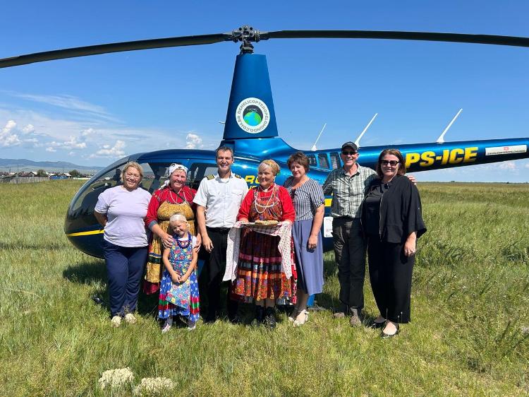 André Borges de Freitas e Peter Wilson ao lado de família em região da Rússia onde fizeram uma escala durante volta ao mundo de helicóptero