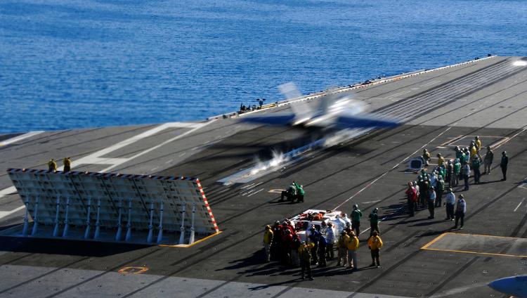 F/A-18C é catapultado do porta-aviões USS Nimitz. Jato de ar do caça rebate no defletor, o que ajuda na decolagem