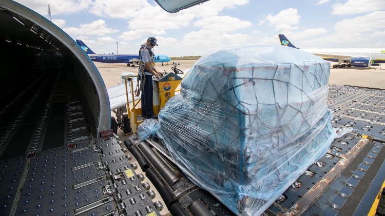  mercadorias são separadas por destino, carregadas em paletes/lâminas e colocadas no avião por meio de plataformas elevatórias