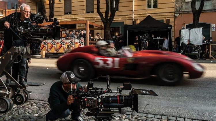 O diretor Michael Mann (em pé à esq.) comanda as filmagens de 'Ferrari'