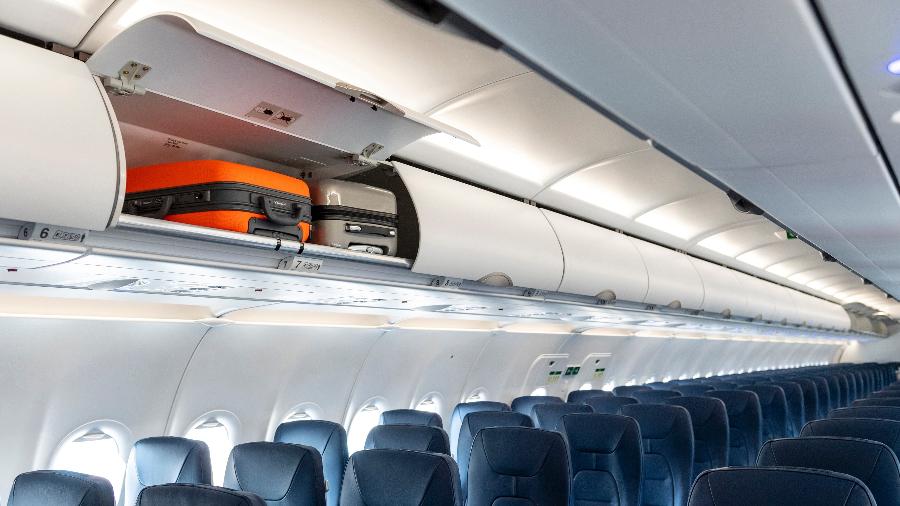 Interior de avião com bagageiro sem espaço para levar uma mala no tamanho padrão por passageiro