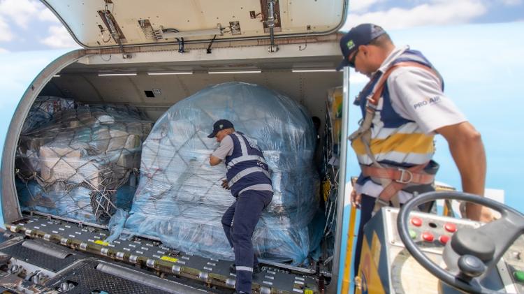  Paletes/lâminas são empurradas manualmente dentro da aeronave