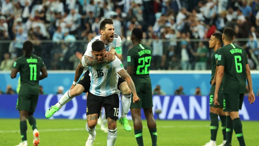 Messi pula nas costas de Marcos Rojo para comemorar o gol - Richard Heathcote/Getty Images