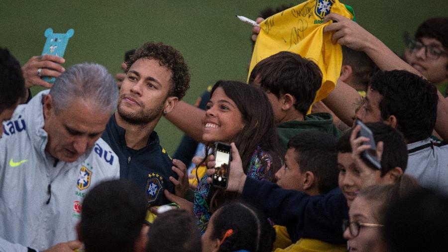 Neymar e Tite atendem os poucos torcedores que tiveram chance de ver a seleção de perto em um treino, ainda na Granja Comary - Pedro Martins/Mowa Press